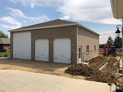 Custom Three Car Detached Garage - 40x50, hip roof, 15' tall walls, all brick, 12" overhangs, 1- 14x14 overhead door, 2 - 8x9 overhead doors